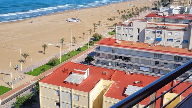 A coastal cityscape with a beach, buildings, and a clear sky. - Don Ximo 13º  Solo Familias! (Playa de Gandía)