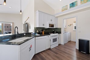 A modern kitchen with white cabinetry, a built-in microwave, a dishwasher, and a stove. - 🌴Private Screened Pool Home | Walk to Ft Myers Beach | Palm Island🌴 (Fort Myers Beach)