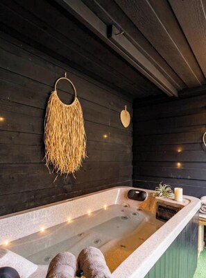 Un espacio de spa con un jacuzzi, toallas y decoración en las paredes.