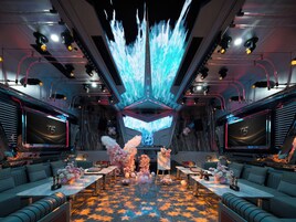 A luxurious interior with a central table, seating, and a large screen displaying a waterfall.