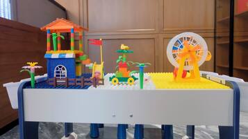 Un set de LEGO con una casa pequeña, un coche, un molino y una jirafa.