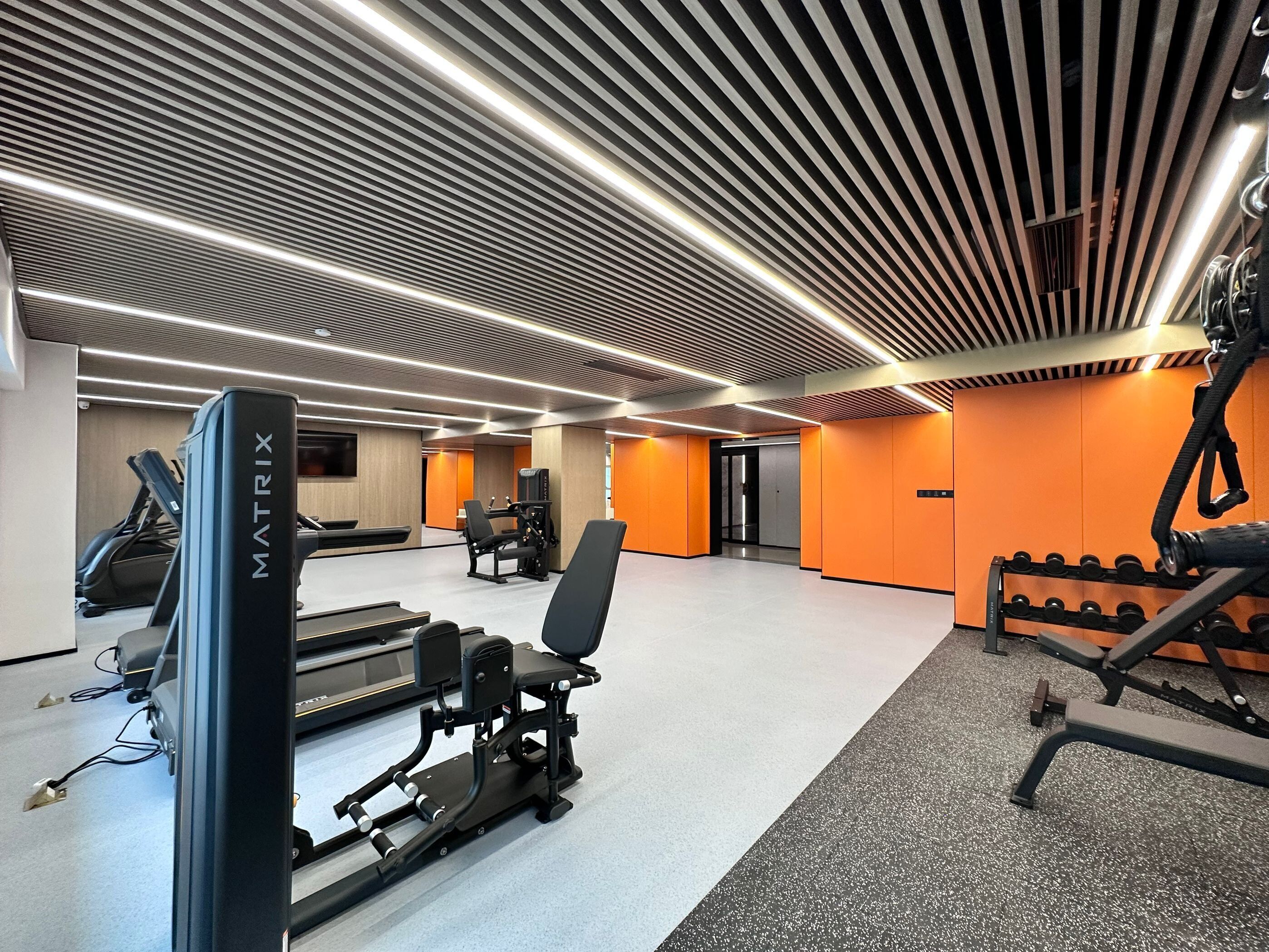 Een moderne sportschool met loopbanden, krachttoestellen en gewichten.