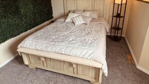 A bedroom with a bed, a green wall, and three paintings. - Rustic-modern style Alaskan retreat (Anchorage)