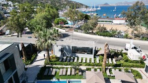 A modern building with a pool, lounge chairs, and a view of the sea. -  ARCADIA OF BODRUM (Bodrum)