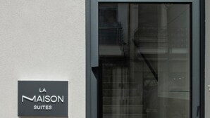A modern building entrance with a glass door and a sign reading "LA MAISON SUITES". - La Maison Suite   Suite 2 (Zakynthos)