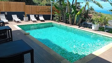 Alberca al aire libre y camastros