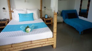 Una cama con dosel, una mesita de noche y un sofá azul.