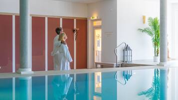A swimming pool with a clear reflection, a couple embracing, and a plant in the corner.