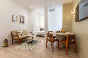 Una sala de estar moderna con sofá, mesa de centro y comedor.