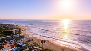 Uma área residencial costeira com casas, praia e oceano.