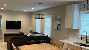 Una cocina moderna con comedor, armarios empotrados y un televisor de pantalla plana.