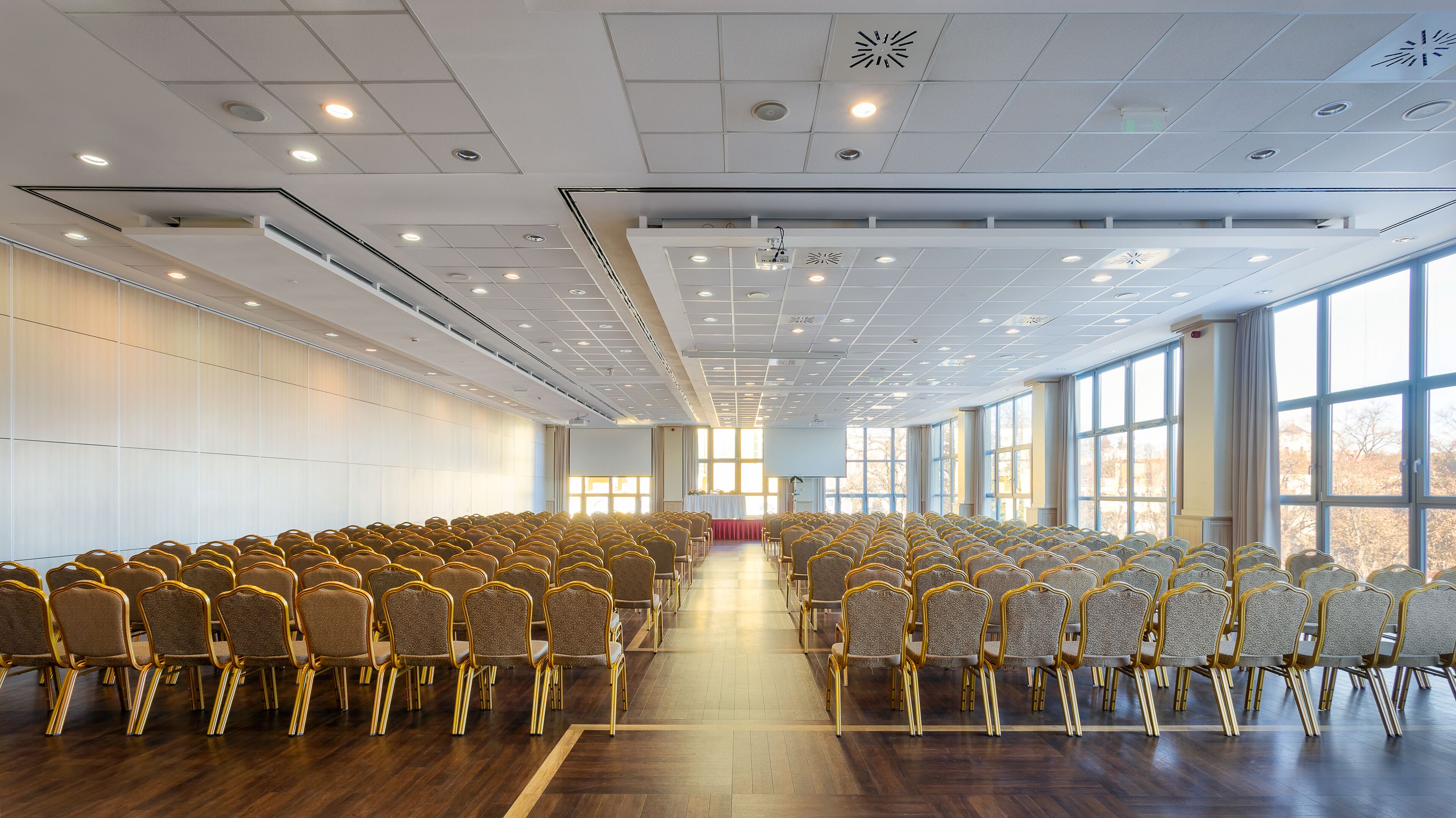 A conference room with rows of chairs and a stage at the front.
