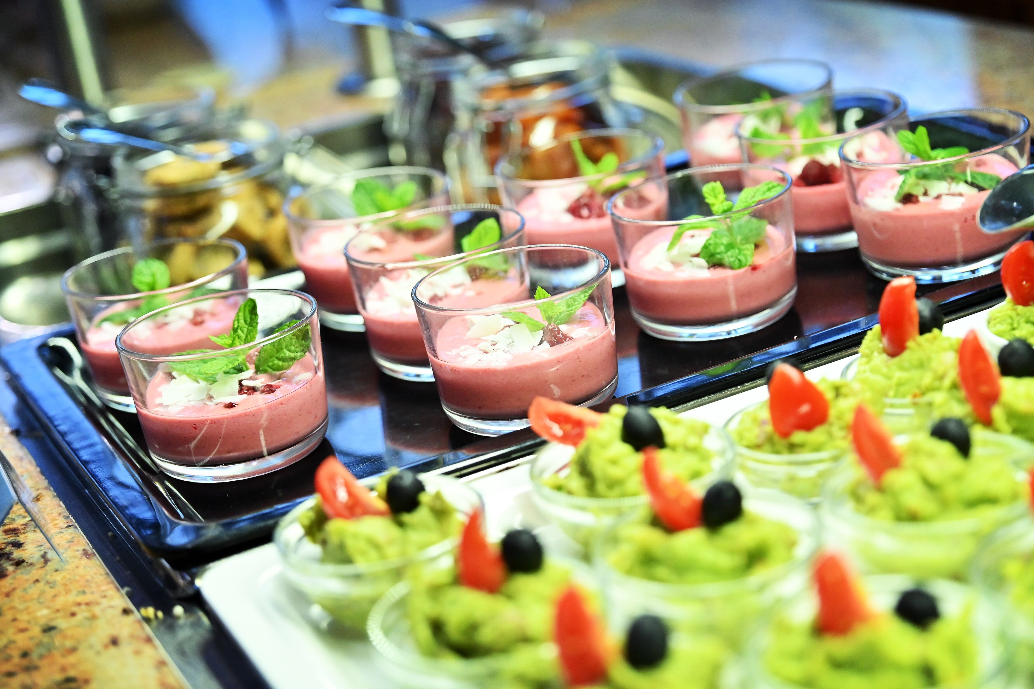 Un bufé con diversos alimentos, incluyendo postres y aperitivos.