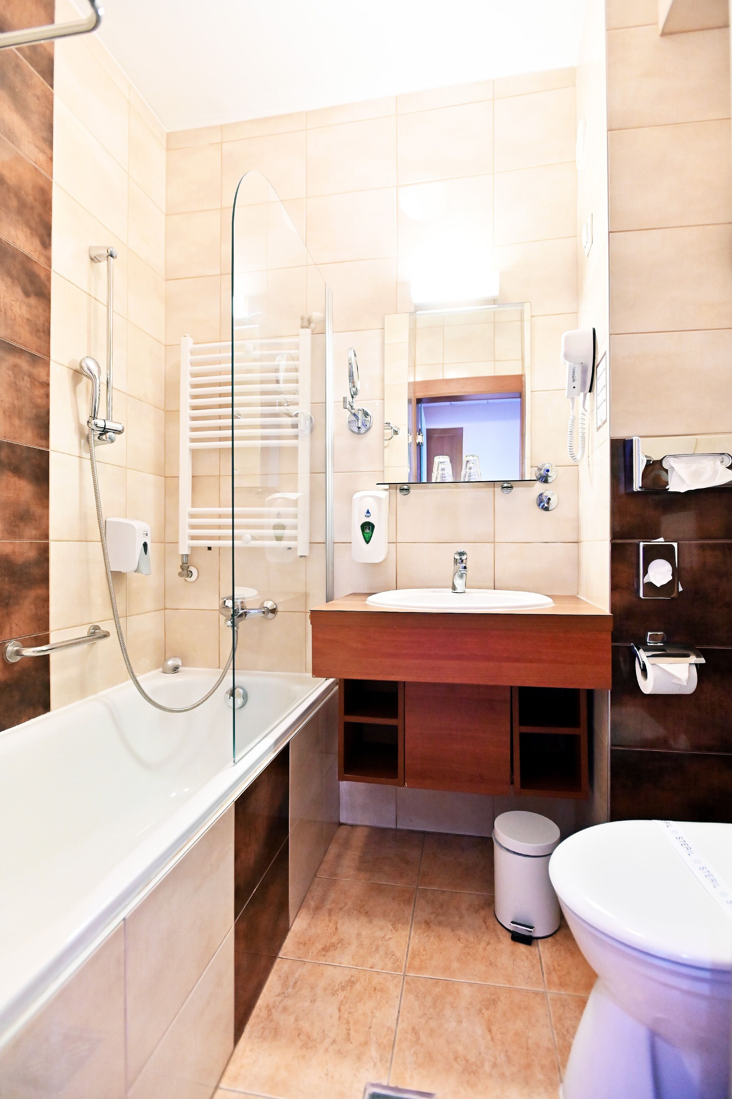 A modern bathroom with a glass-enclosed shower, a white sink, and a toilet.