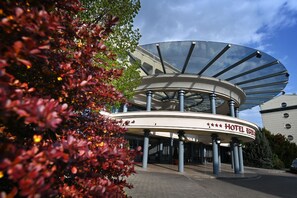 Um hotel com uma estrutura circular de vidro distinta e uma placa com a inscrição 'HOTEL EGER'.