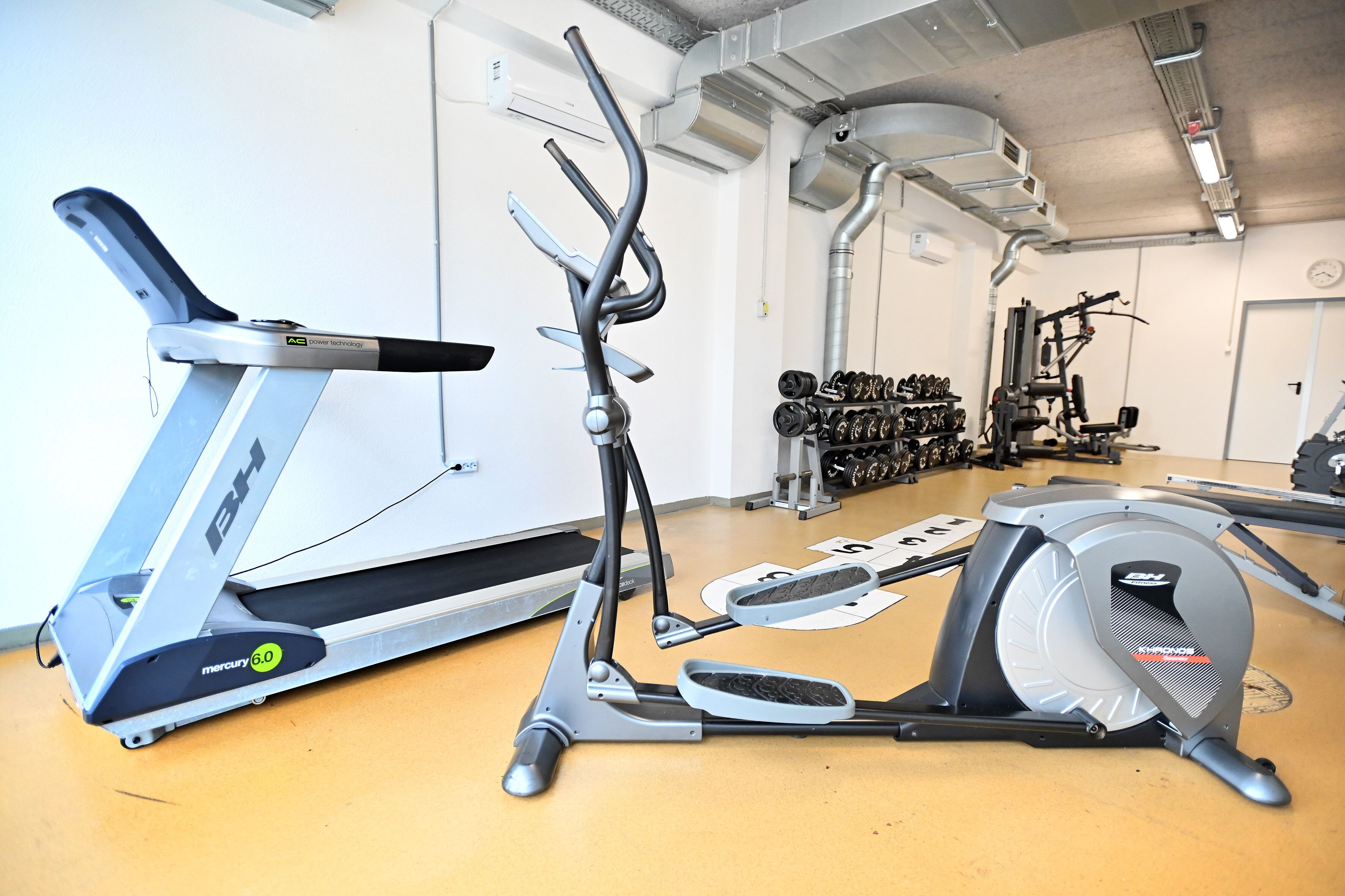 A gym with cardio equipment including treadmills and an elliptical machine.