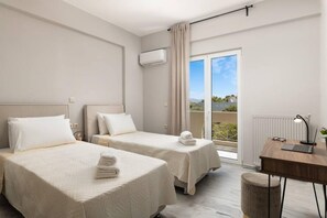 A hotel room with two beds, a desk, a chair, and a view of the outdoors. - Procris Villas Breathtaking Sea View (Chania)