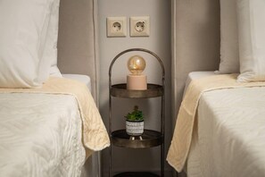 A room with two beds, a wall-mounted shelf with a spherical light, and two electrical outlets. - Procris Villas Breathtaking Sea View (Chania)