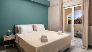 A bedroom with a bed, a nightstand, a window, and a view of the outside.