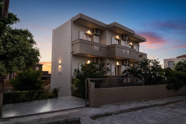 Stylish residential building with a flat roof, symmetrical facade, and balconies.