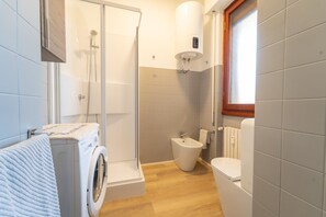 A compact bathroom with a washing machine, a bidet, and a toilet. - Le Orchidee by Wonderful Italy (Sanremo)