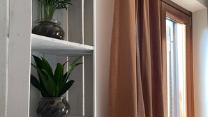 Een witte plank met twee potplanten tegen een muur.