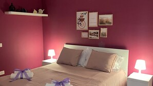 Een slaapkamer met een groot bed, twee nachtkastjes en een wandplank.