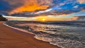 Una spiaggia con onde e un tramonto.