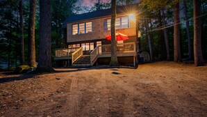 A two-story cabin with a wooden deck and stairs leading to the entrance. - Pine and Eagle- Family & Dog Friendly Great Views (Sebago)
