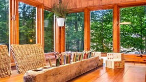 A wooden interior with a long, rustic planter filled with colored pencils, a woven chair, and a wooden block game. - Pine and Eagle- Family & Dog Friendly Great Views (Sebago)