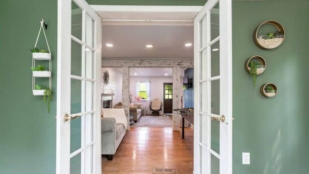 A spacious hallway with a wooden floor leading to a living area with a sofa and a coffee table.