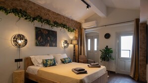 Un dormitorio con una cama de madera, una lámpara de pared, un cuadro y una planta en maceta.