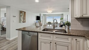 A modern kitchen with granite countertops, stainless steel appliances, and white cabinetry. - Amelia Surf & Racquet Club Condo 5th Floor Oceanview Pools Tennis Court Sleeps 4 (Fernandina Beach)