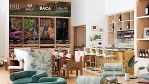 A modern bar area with wine bottles, seating, and a large wine rack.