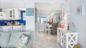 A modern kitchen with white cabinets and a dining area with a white table and chairs.