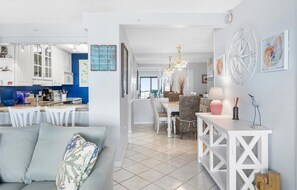 A modern kitchen with white cabinets and a dining area with a white table and chairs.