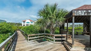 A wooden deck with a view of a house and a palm tree. - 2 King Beds - Walk to Beach (St. Augustine)