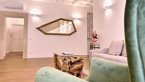 Een moderne woonkamer met een lichtgroene bank, een houten salontafel en een grote spiegel aan de muur.