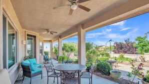 A covered patio with wicker furniture, a round table, and ceiling fans. - Hole in One! Luxury Home Near Golf Course, Airport, Embry Riddle (Prescott)