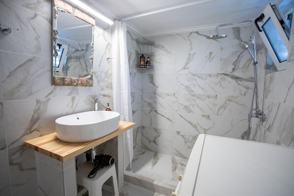 Bathtub, hair dryer, towels, toilet paper