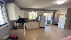 A modern kitchen with white cabinets, a built-in oven, and a refrigerator.