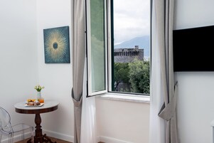 Una habitación con una mesa de comedor, un jarrón con flores y vistas a un edificio histórico a través de una ventana.