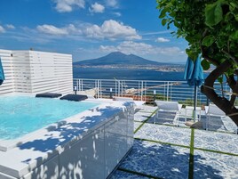 Una piscina en la azotea con vista al mar y a la montaña.