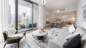 A modern living room with a large window, a round coffee table, and a sofa. - EDEN'S Homes & Villas - LIV Residence (Dubai)