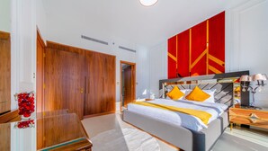 Ein modernes Schlafzimmer mit einem großen Bett, einem Holzschrank und einer leuchtend roten Wand.