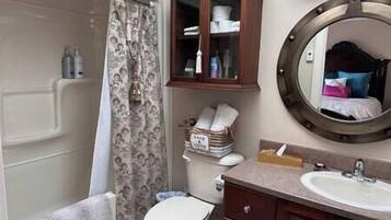 Ein Badezimmer mit Toilette, Waschbecken, Spiegel und Schrank.
