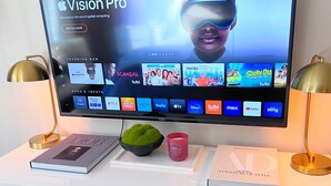 A flat-screen TV on a white table displaying the Vision Pro app interface. - 3bed -2bath Retreat Sleeps up to 9 w/Amenities+LargerTerrace+Bay Views & Sunset! (Petoskey)