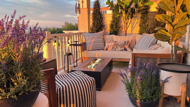 A cozy outdoor seating area with a sofa, fire pit, and potted plants. - 3bed -2bath Retreat Sleeps up to 9 w/Amenities+LargerTerrace+Bay Views & Sunset! (Petoskey)