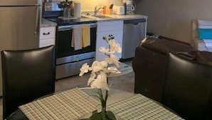 A compact kitchen with modern appliances, a dining area with a table and chairs, and a staircase leading to another level. - Cozy Branson Getaway (Branson)