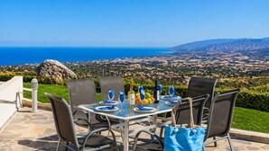 Una mesa al aire libre con vistas despejadas al mar y al paisaje.
